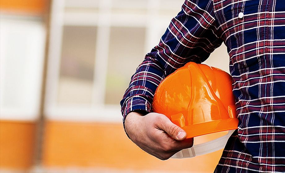 Conducteur tenant sous le bras son casque de chantier - 35 ans d’expertise en location de bennes